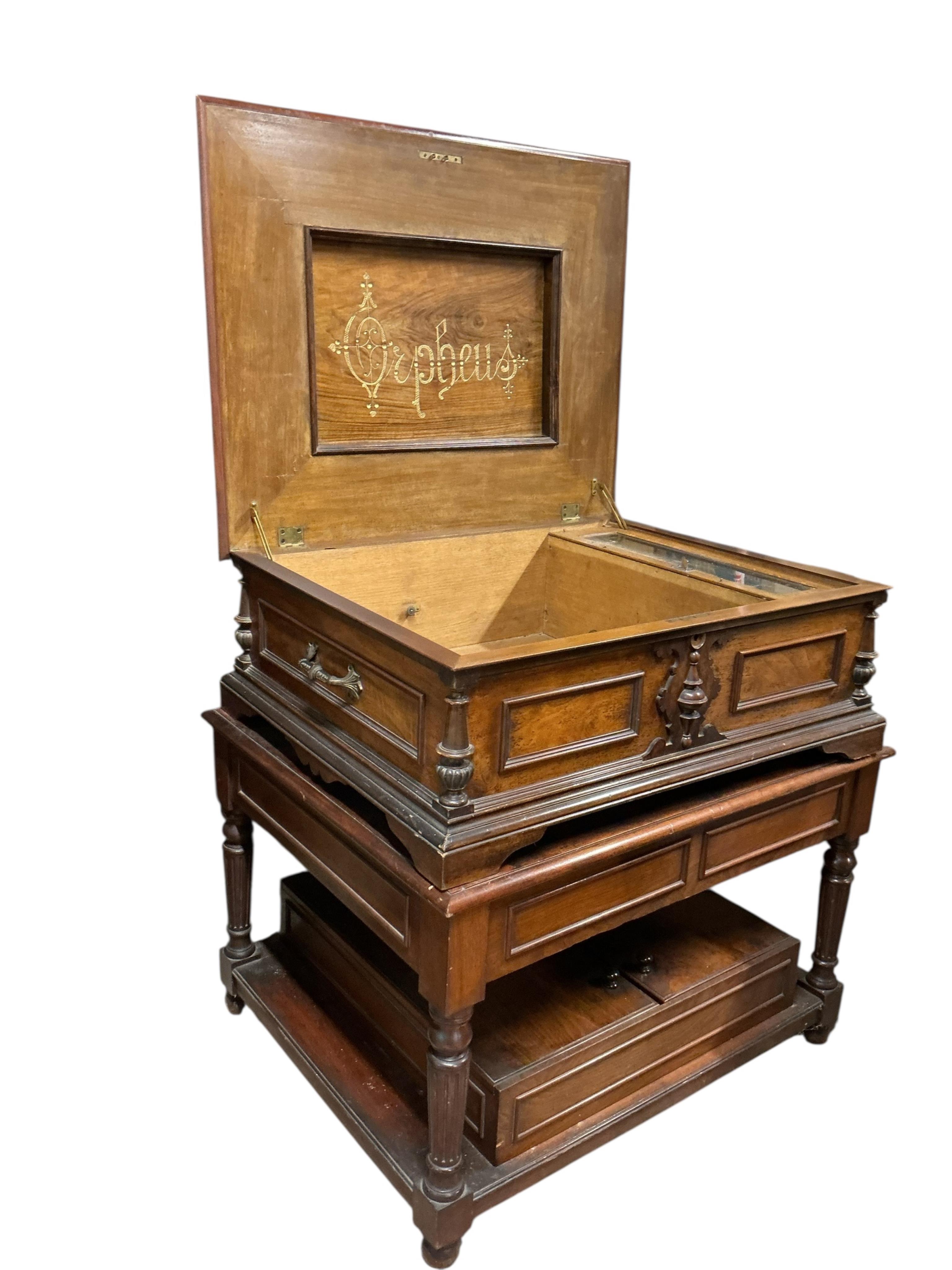 A substantial early 20th century inlaid walnut cased tabletop Orpheus polyphon on a floor standing base containing a compartment for storing the discs, together with thirty-seven 57.5cm diameter discs, and a winding hand